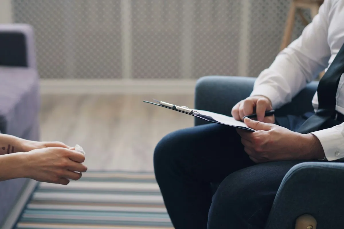 Clinician with a clipboard listening to a client during an assessment